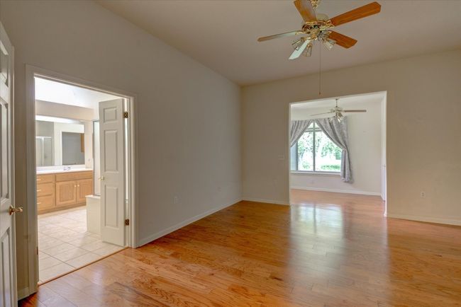 Primary room with ceiling fan and light wood-type flooring | Image 15