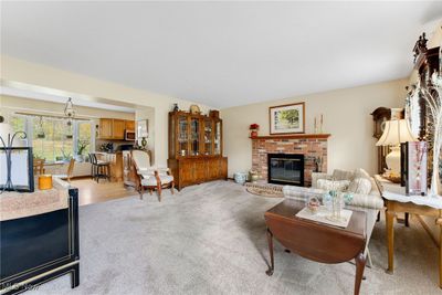 Carpeted living room with a fireplace | Image 2