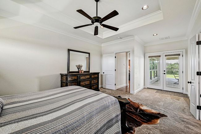 Carpeted bedroom featuring a raised ceiling, access to exterior, crown molding, french doors, and recessed lighting | Image 18