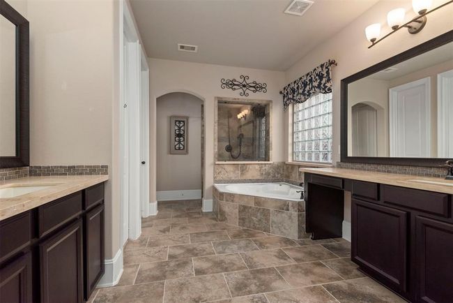 Luxurious primary bedroom ensuite with double sinks, great counter space/storage, vanity area, soaking tub, separate shower and 2 walk in closets. | Image 23