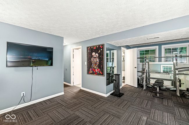 exercise room with carpet and a textured ceiling | Image 21