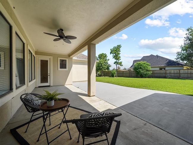 Spacious covered patio with a fan, offering a stunning view of the expansive backyard! Plenty of space to create your own backyard oasis! | Image 45