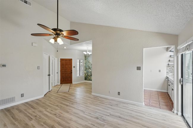 Unfurnished living room with ceiling fan, LVT flooring and a vaulted ceiling | Image 9