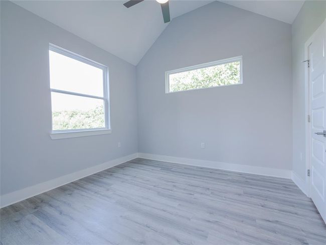 Unfurnished room featuring healthy amount of natural light, a ceiling fan, light wood-type flooring, and lofted ceiling | Image 21