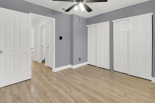Unfurnished bedroom featuring multiple closets, light wood-style flooring, and a ceiling fan | Image 15