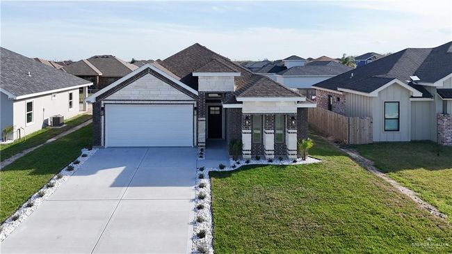 View of front of house featuring an attached garage, fence, cooling unit, driveway, and a front lawn | Image 4