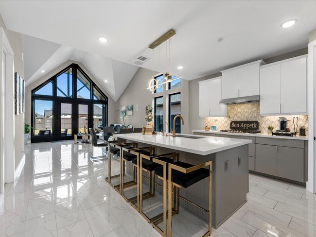 the modern residence features an Open concept with modern touches and a pointed vaulted ceiling with a home theater speaker and sound system already installed make this home the perfect space for family and entertaining | Image 9