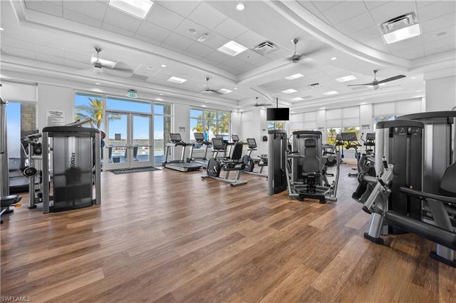 Gym with french doors, visible vents, a paneled ceiling, ceiling fan, and wood finished floors | Image 38