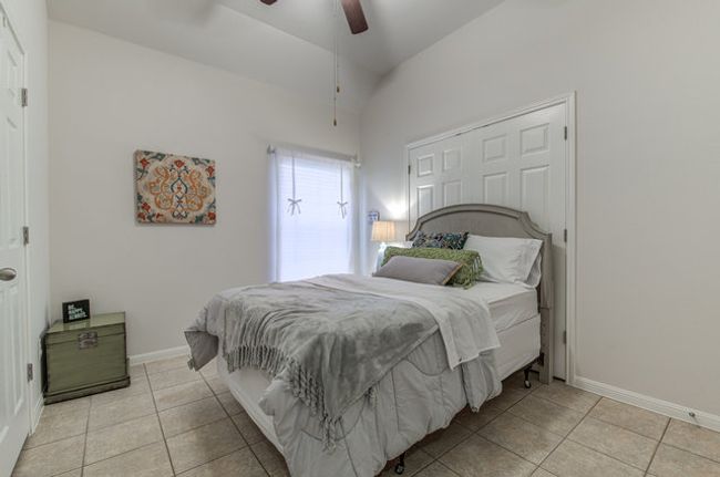 Bedroom with tile patterned floors, baseboards, and a ceiling fan | Image 14
