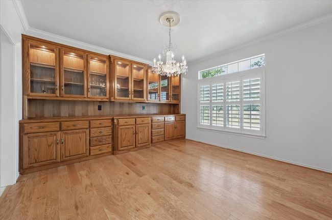 Unfurnished dining area with light wood-style flooring, a chandelier, and ornamental molding | Image 14