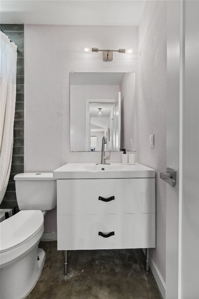 Bathroom featuring concrete floors, vanity, toilet, baseboards, and a shower with curtain | Image 24
