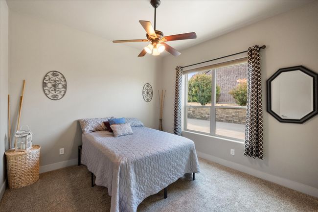 Spacious bedroom with fan and large windows | Image 20