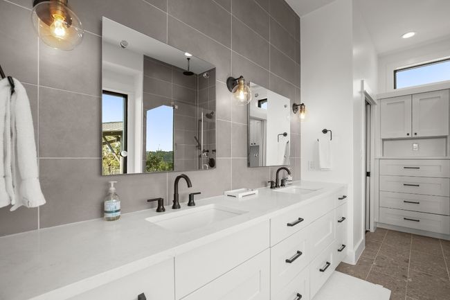 En suite primary bathroom with dual vanity and built-in storage. | Image 12