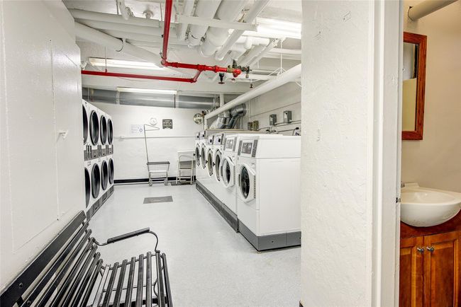 Community laundry room with washing machine and dryer and a textured wall | Image 25