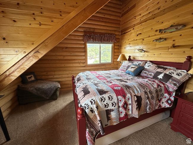 Carpeted bedroom featuring log walls | Image 15