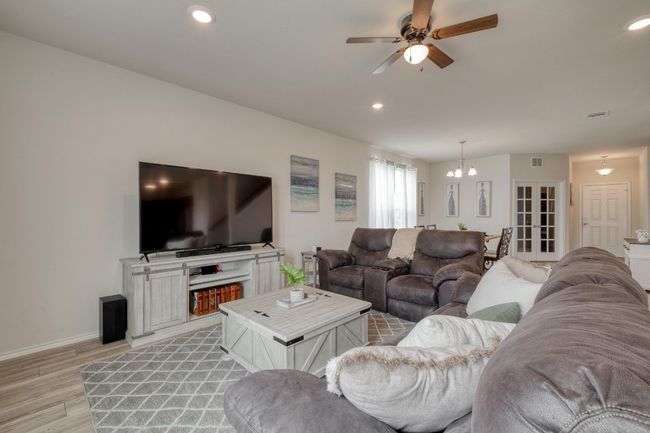 Living room featuring recessed lighting, light wood-type flooring, and ceiling fan with notable chandelier | Image 10