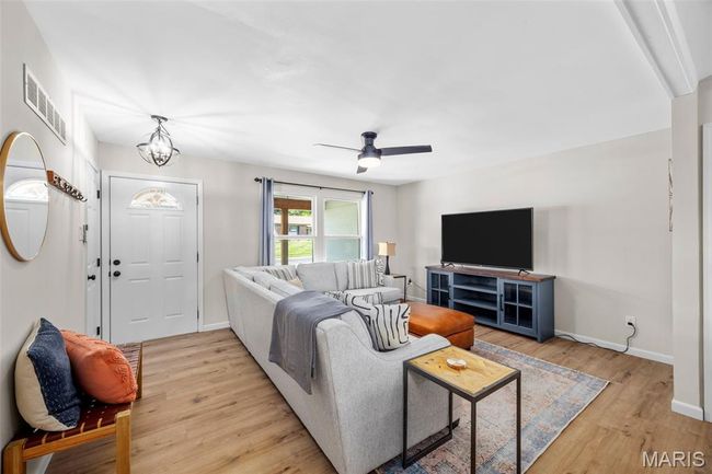 Living area featuring light wood-style flooring and ceiling fan | Image 7