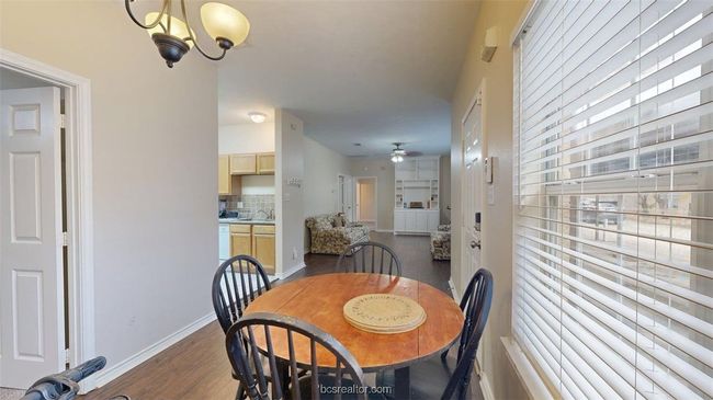 Dining room featuring dark wood-style flooring, baseboards, and ceiling fan with notable chandelier | Image 10