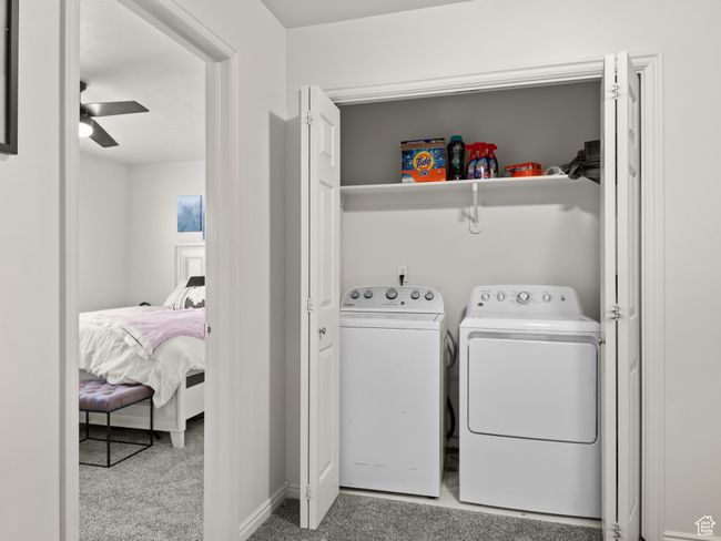 Laundry area featuring washer and dryer, ceiling fan, and light colored carpet | Image 26