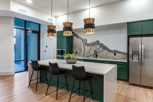 Kitchen featuring light hardwood / wood-style flooring, a kitchen bar, a kitchen island, and stainless steel refrigerator with ice dispenser | Image 34