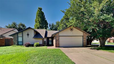 Ranch-style house with a garage and a front yard | Image 2