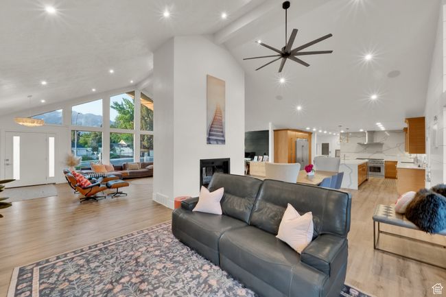 Living area featuring high vaulted ceiling, light wood-type flooring, ceiling fan, recessed lighting, and beam ceiling | Image 9