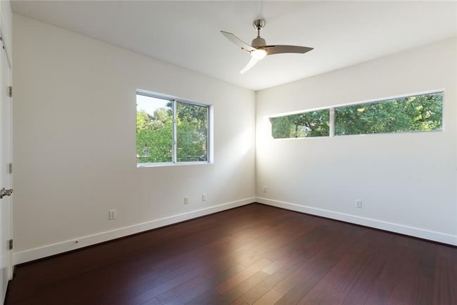 Spare room featuring baseboards, dark wood-style floors, and a ceiling fan | Image 27