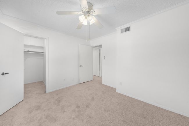 Upstairs bedroom 3 with updated carpet, ceiling fan and walk in closet. | Image 19