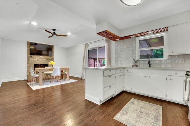 Kitchen featuring a ceiling fan, tasteful backsplash, light countertops, a peninsula, and recessed lighting | Image 9