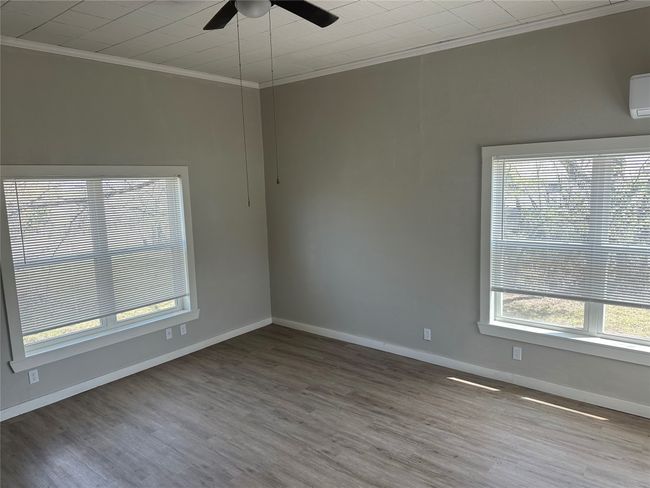 Spare room featuring baseboards, wood finished floors, ornamental molding, and a ceiling fan | Image 21