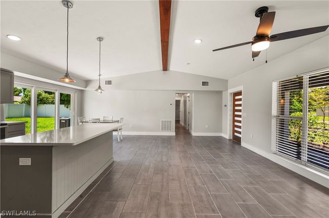 Kitchen featuring a center island, dark hardwood / wood-style flooring, ceiling fan, pendant lighting, and lofted ceiling with beams | Image 17