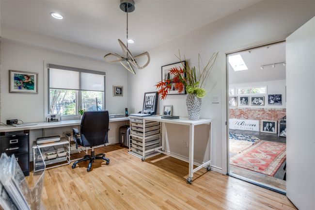 Office space with a skylight, light hardwood / wood-style floors, and rail lighting | Image 15