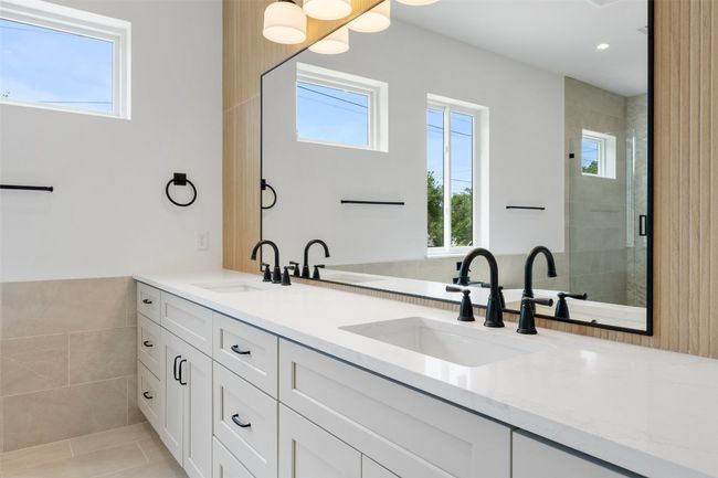 Bathroom featuring healthy amount of natural light, a shower stall, double vanity, tile patterned floors, and tile walls | Image 19
