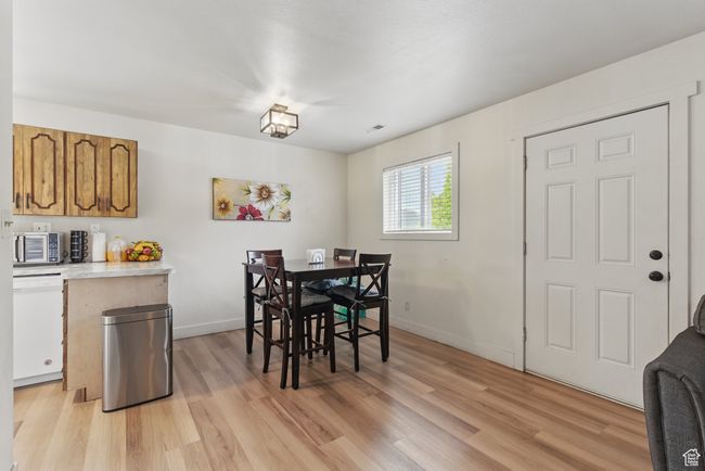 Dining area featuring visible vents, light wood-style flooring, and baseboards | Image 15