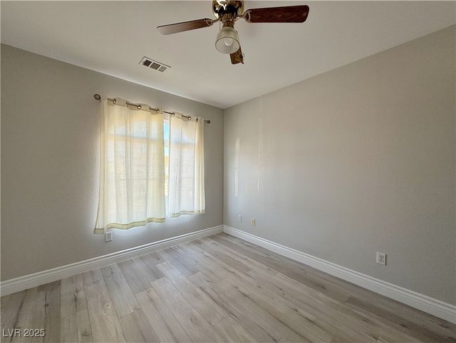 Unfurnished room with ceiling fan, baseboards, visible vents, and light wood-type flooring | Image 36