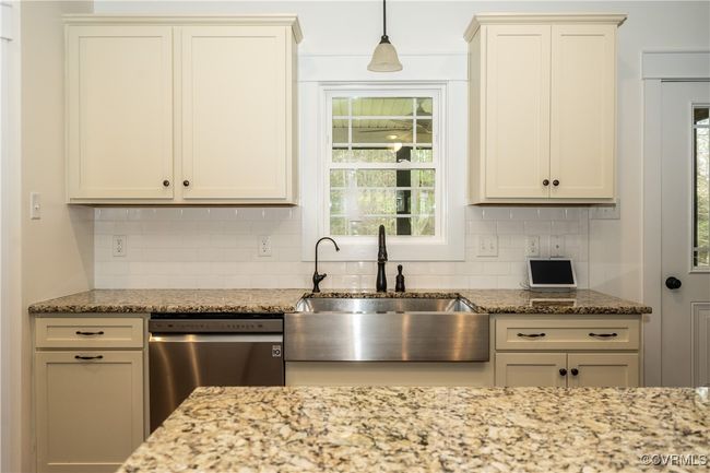 Kitchen featuring a sink, a wealth of natural light, light stone counters, and dishwasher | Image 13