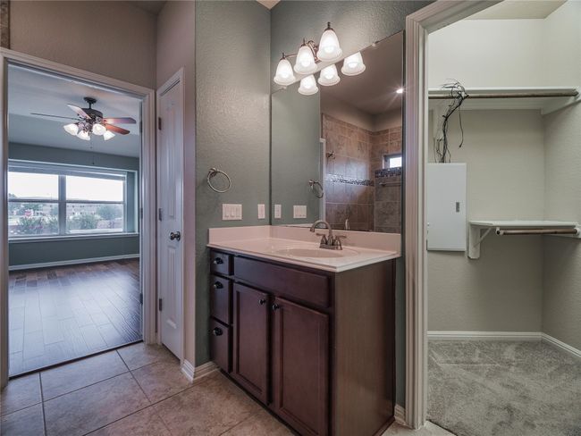 Full bath with vanity, ceiling fan, baseboards, a tile shower, and tile patterned floors | Image 27