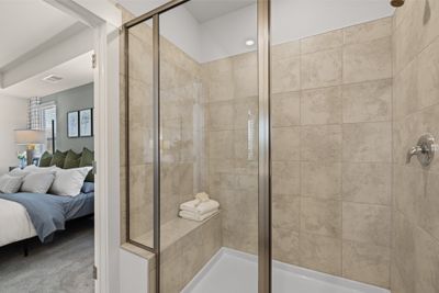 Unwind in a spa like shower! Shower has a semi-frame less door, a bench, and had ceramic tiled walls. Photo is of Welcome Home Center in another Lennar community. Finishes may vary. | Image 3