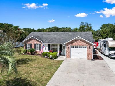 Ranch-style house featuring a front yard and a garage | Image 1