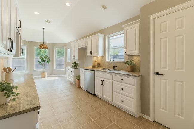 Kitchen featuring stainless steel dishwasher, a sink, visible vents, and a wealth of natural light | Image 16