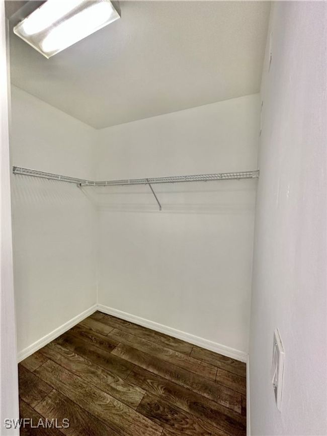 Walk in closet with dark wood-type flooring | Image 16