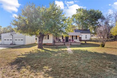 View of front of property featuring a front yard, a garage, and covered porch | Image 1