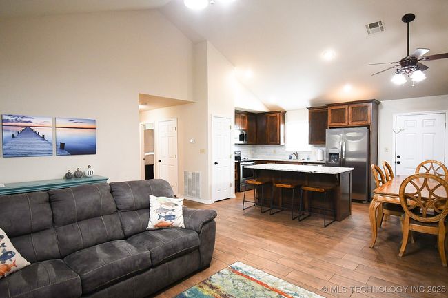 Living room with ceiling fan, light wood-style flooring, and high vaulted ceiling | Image 10