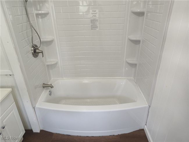 Full bath featuring vanity, shower / tub combination, and wood finished floors | Image 31