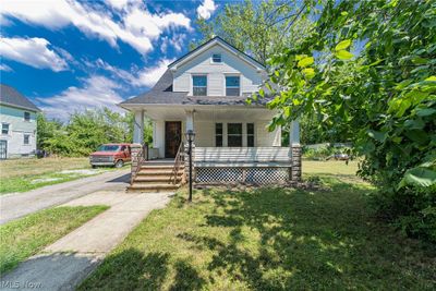 Bungalow-style home with covered porch and a front yard | Image 1