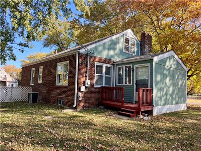 Rear view of property with a deck, a lawn, and central AC unit | Image 1