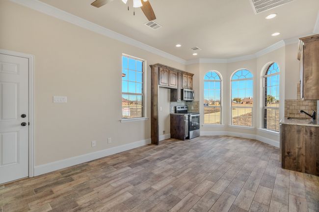 Kitchen featuring appliances with stainless steel finishes, light wood-style flooring, decorative backsplash, recessed lighting, and crown molding | Image 28