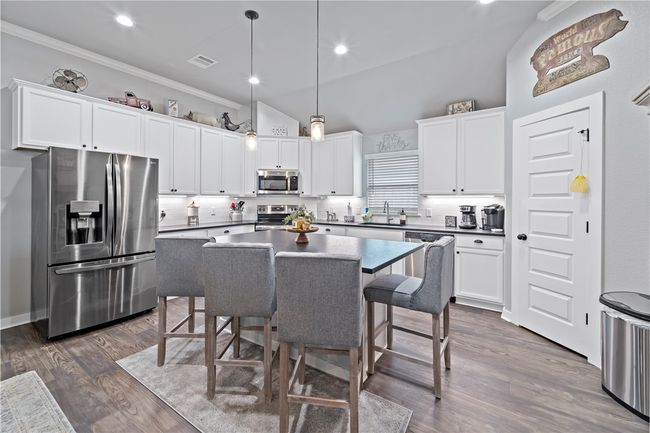 Kitchen featuring visible vents, ornamental molding, appliances with stainless steel finishes, a sink, and dark wood-style floors | Image 13