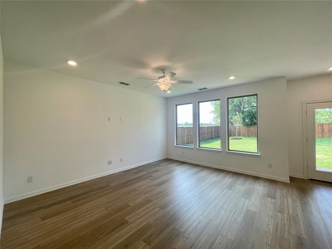 Empty room featuring ceiling fan, dark wood-style flooring, and recessed lighting | Image 9