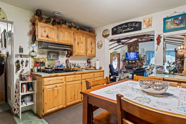 Kitchen with under cabinet range hood, light countertops, and open floor plan | Image 23